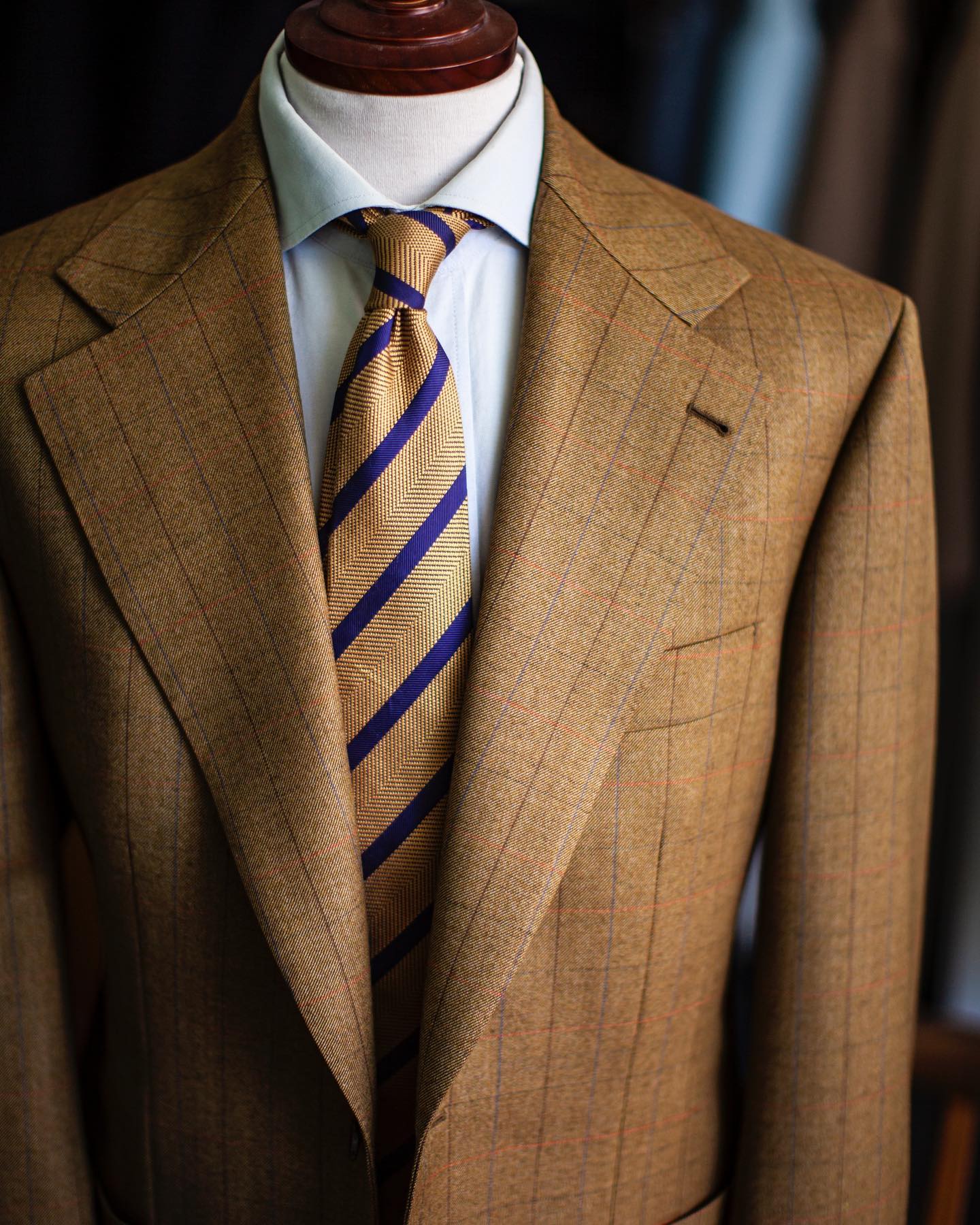 Brown plaid suit blazer with light brown blue purple striped necktie